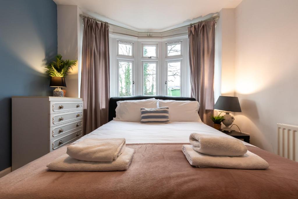 um quarto com uma cama grande com duas almofadas em Accessible 3-bedroom bungalow with patio +driveway em Southampton