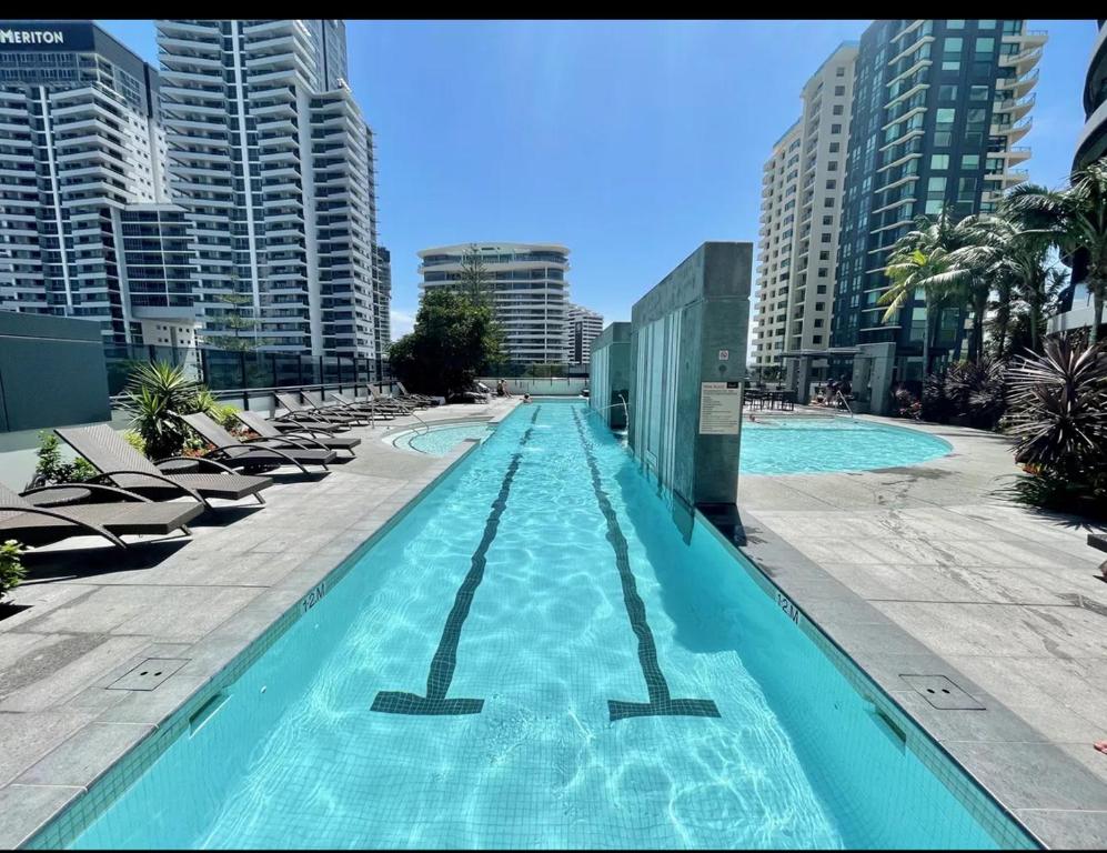 una gran piscina con tumbonas y edificios en Oracle resort apartment, en Gold Coast