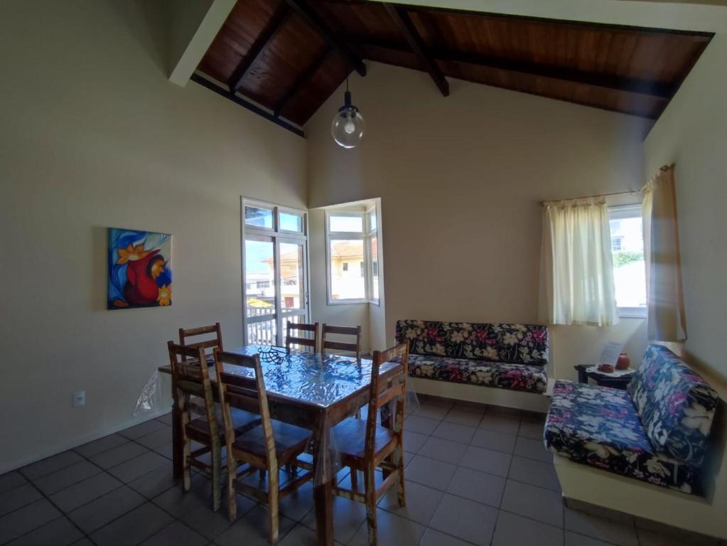 a dining room with a table and chairs and a couch at Apartamento residencial solar dos Golfinhos - 204 in Florianópolis