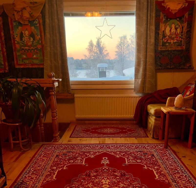 a living room with a window and a red rug at Meditation Room with light bfast - private toilet, no shower in Rovaniemi