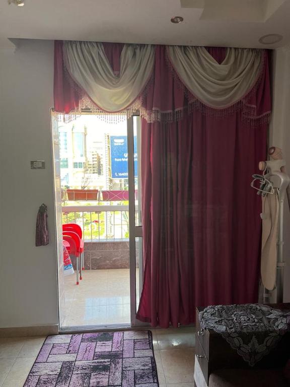 a room with a sliding glass door with red curtains at شقة للايجار مفروشة بالكامل in Cairo