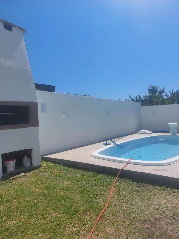 uma piscina ao lado de uma casa em Casa Praia de Xangri-Lá Piscina em Xangri-lá