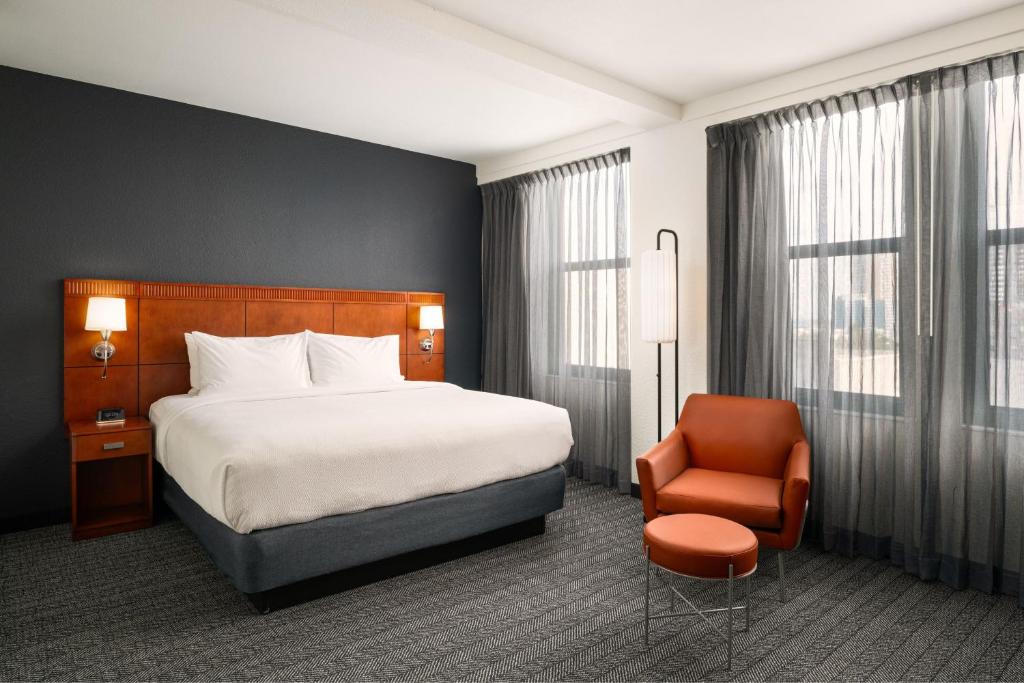 a hotel room with a bed and a chair at Courtyard by Marriott St. Petersburg Downtown in St Petersburg