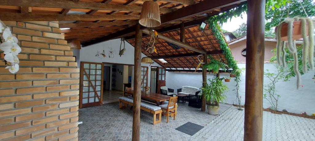 a patio with a table and a brick wall at Casa Canto Verde Camburi in Camburi