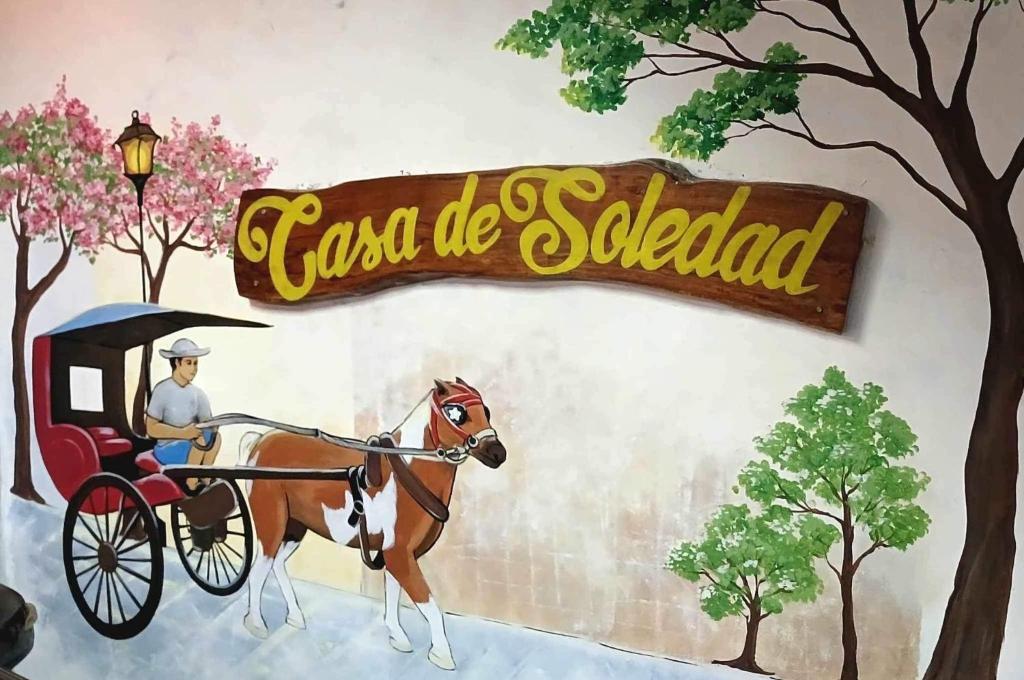 a painting of a man in a horse drawn carriage at Casa De Soledad Vigan City in Vigan