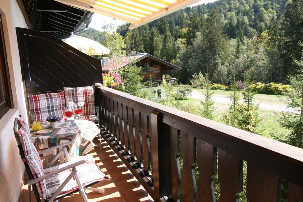 a porch with a table and chairs on a balcony at Alpendohle in Reit im Winkl