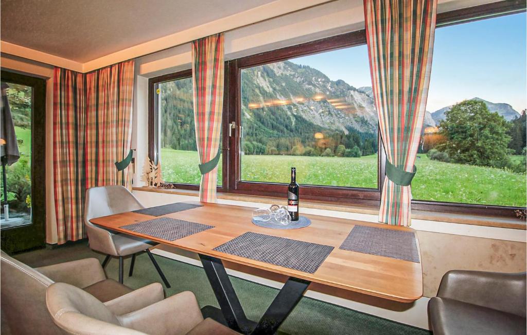 a dining room with a table and a large window at Cozy Home In Tannheim With Wifi in Tannheim