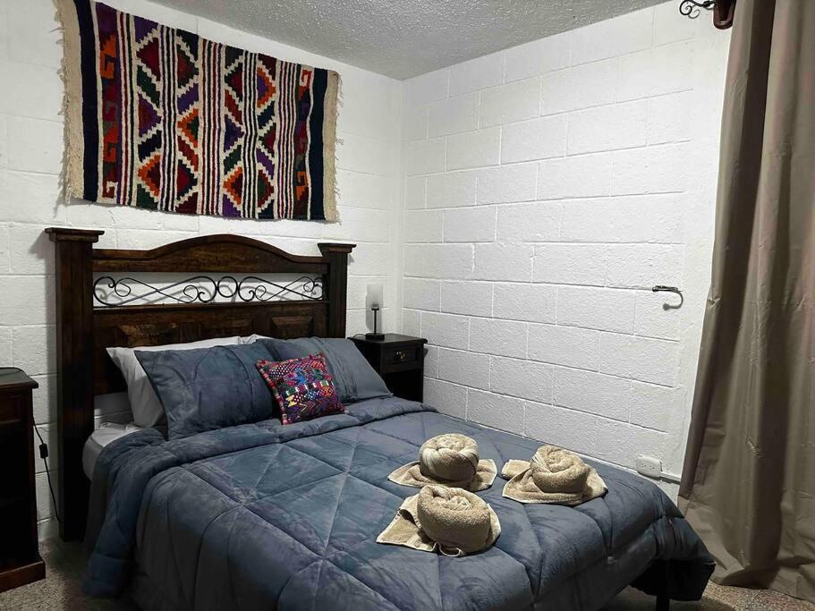 ein Schlafzimmer mit einem Bett mit zwei ausgestopften Tieren darauf in der Unterkunft Apartamento con Lavanderia en Antigua, Guatemala -El Sombreron in Antigua Guatemala