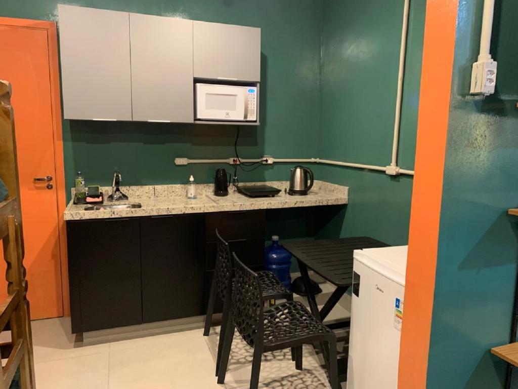 a kitchen with a sink and a table and a microwave at BRÁS Expo Center Norte Feira da Madrugada, shopping vautier 25 março in Sao Paulo