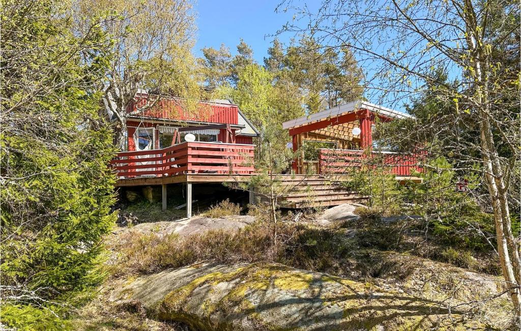 a red house in the middle of a forest at Pet Friendly Home In Gressvik With House A Panoramic View in Gressvik