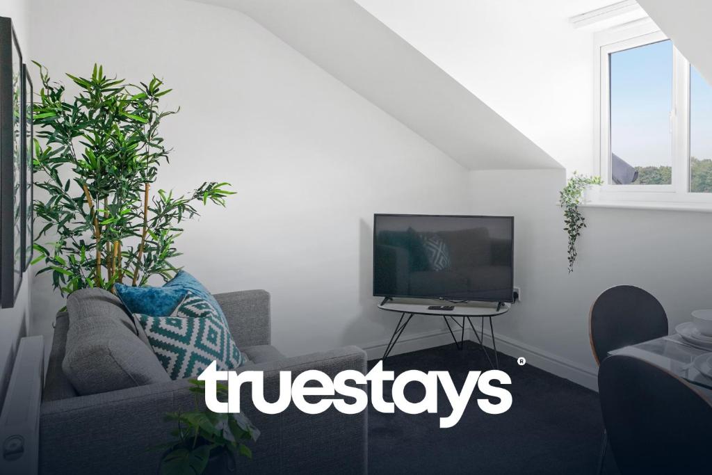 a living room with a couch and a tv at NEW 5 Sarah House by Truestays - 2 Bedroom Apartment - FREE Parking in Manchester