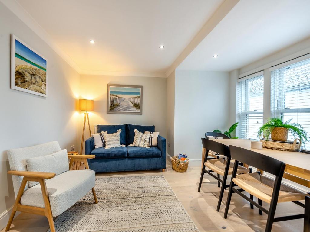 sala de estar con sofá azul y mesa en Sea Breeze en Torquay