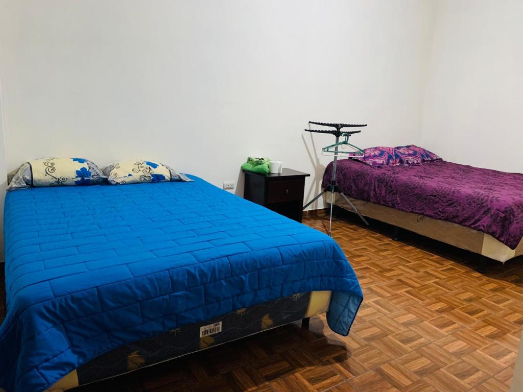 1 Schlafzimmer mit 2 Betten und lila Bettwäsche in der Unterkunft Sucursal del Cielo in Concepción de Ataco