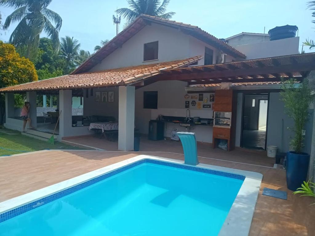 a villa with a swimming pool in front of a house at Casa Da Mari in Vera Cruz de Itaparica