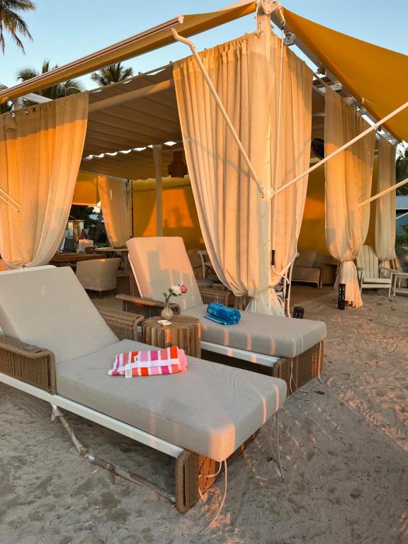 two beds on the beach under a tent at Casa rosada beach front in Mano Juan