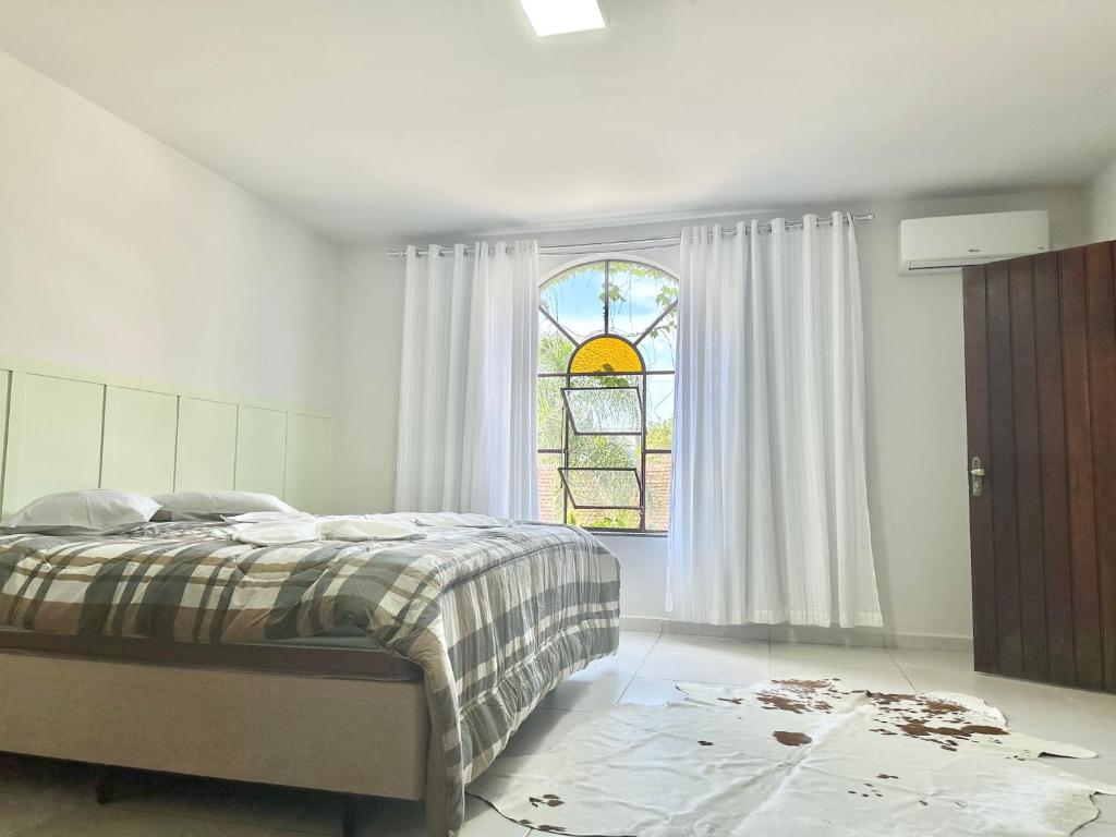 Suíte na casa amarela في بوميرودي: غرفة نوم بسرير ونافذة