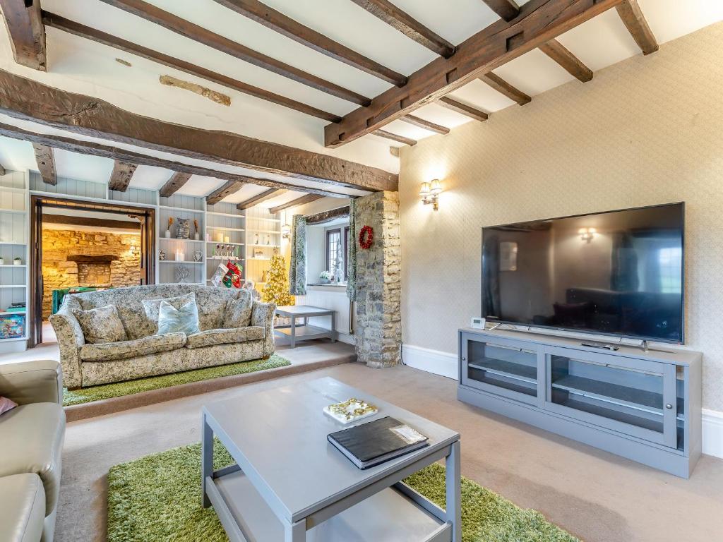 a living room with a large television and a couch at Dale House Farm - Uk46033 in Monyash