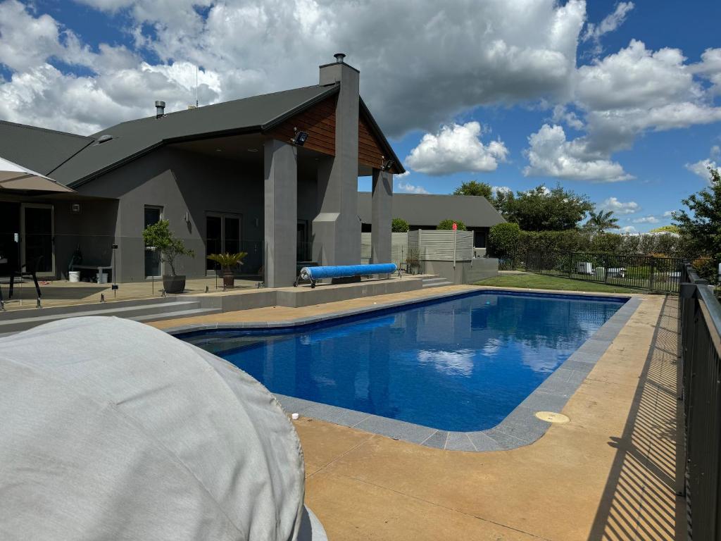 a swimming pool in front of a house at 200 on Lake View in Karapiro
