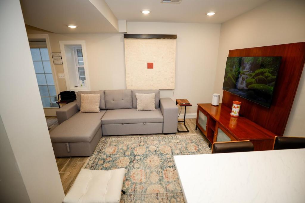 uma sala de estar com um sofá e uma televisão em Amma's Place em Washington
