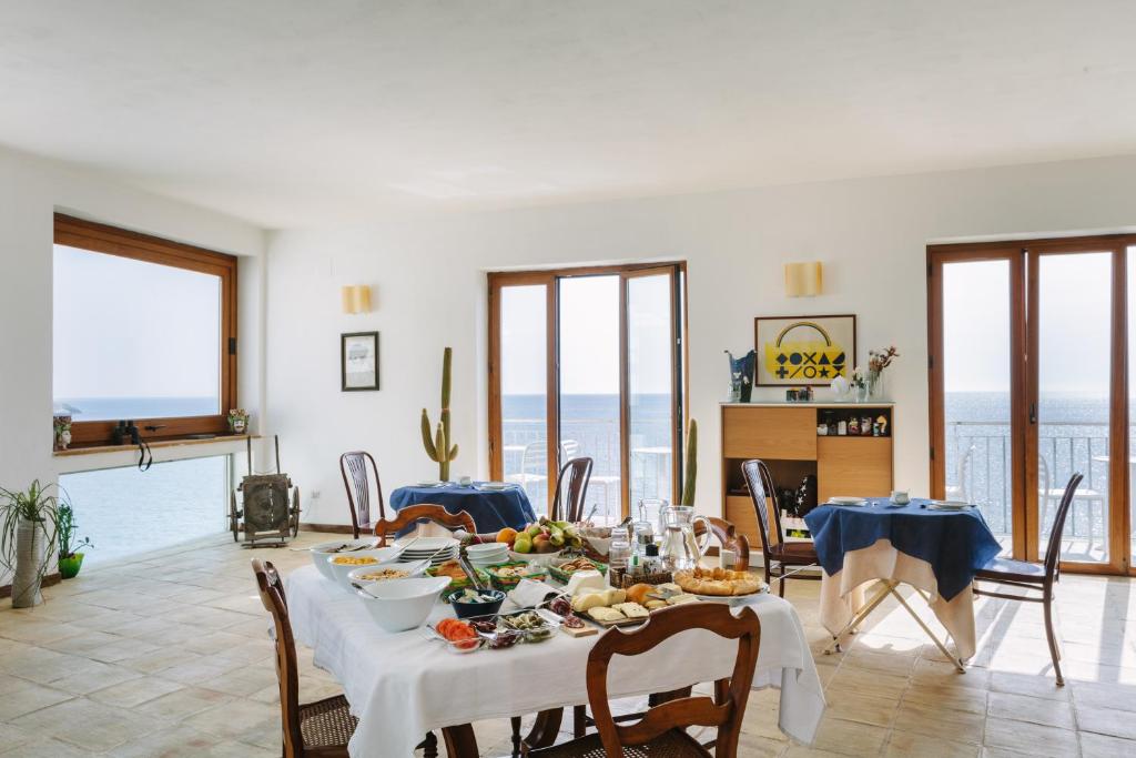 un comedor con una mesa con comida. en Giuggiulena, en Siracusa