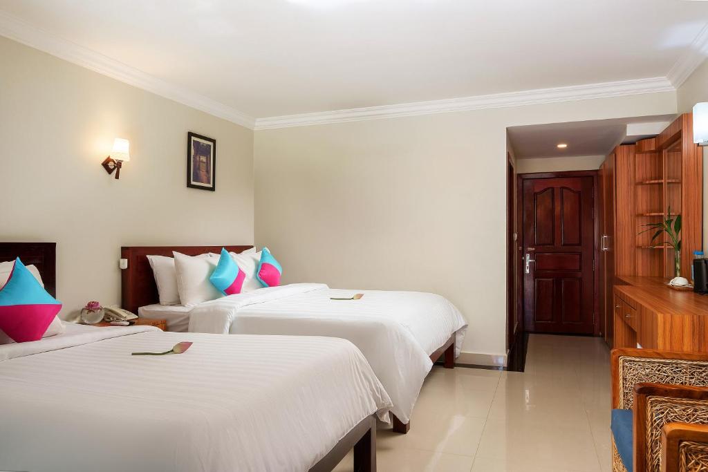 Postel nebo postele na pokoji v ubytování Ratana Angkor Hotel
