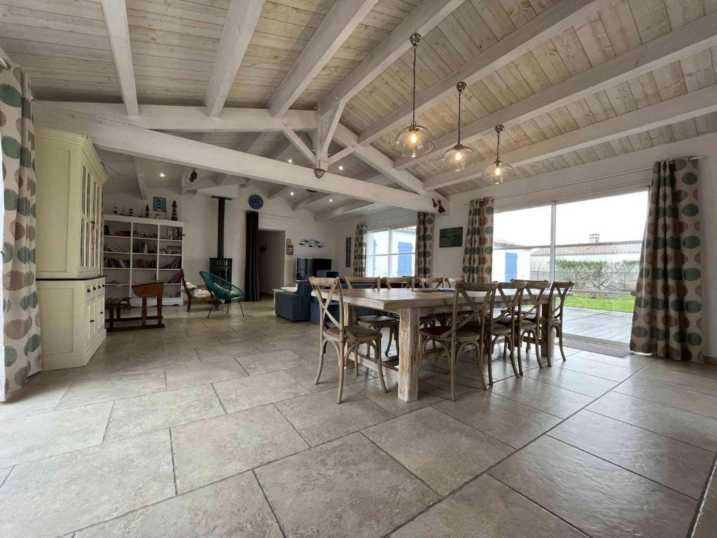 eine Küche und ein Esszimmer mit Tisch und Stühlen in der Unterkunft Villa spacieuse avec piscine privée, WiFi gratuit et jardin clos, à proximité de la mer et du centre-ville - FR-1-246A-279 in Saint-Denis-dʼOléron