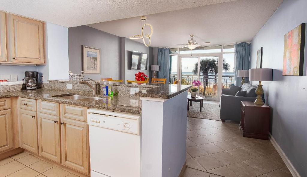 a kitchen with a sink and a living room at Atlantica Resort in Myrtle Beach