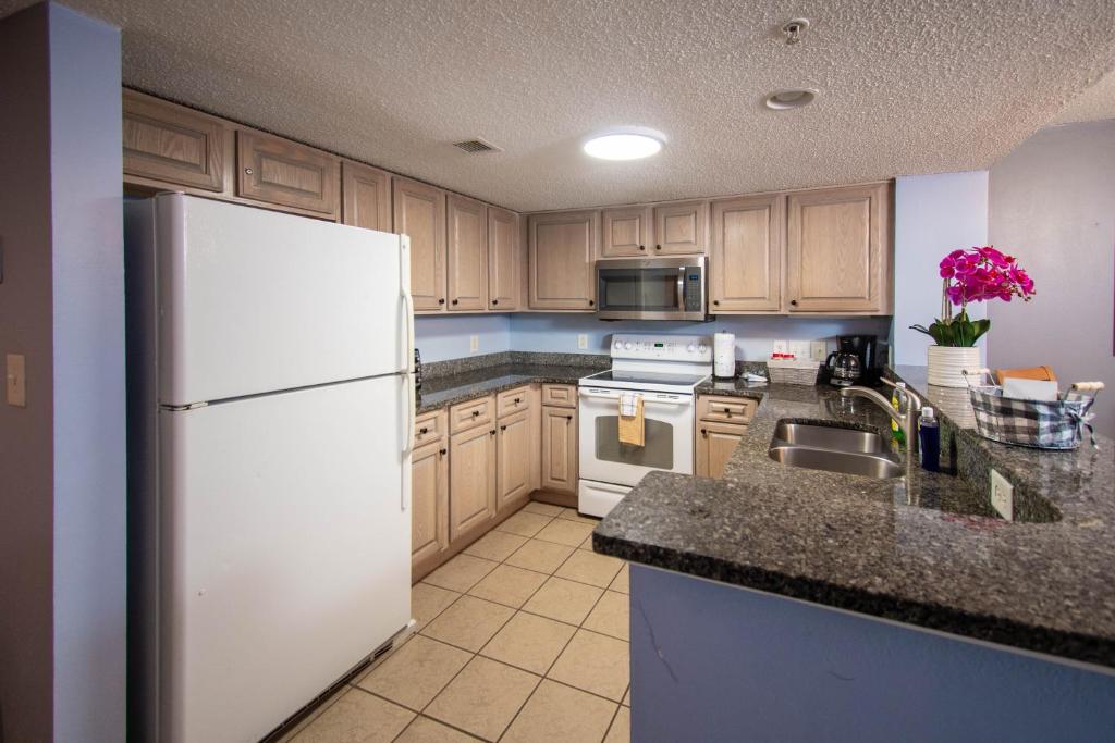 a kitchen with a white refrigerator and a sink at Atlantica Resort in Myrtle Beach