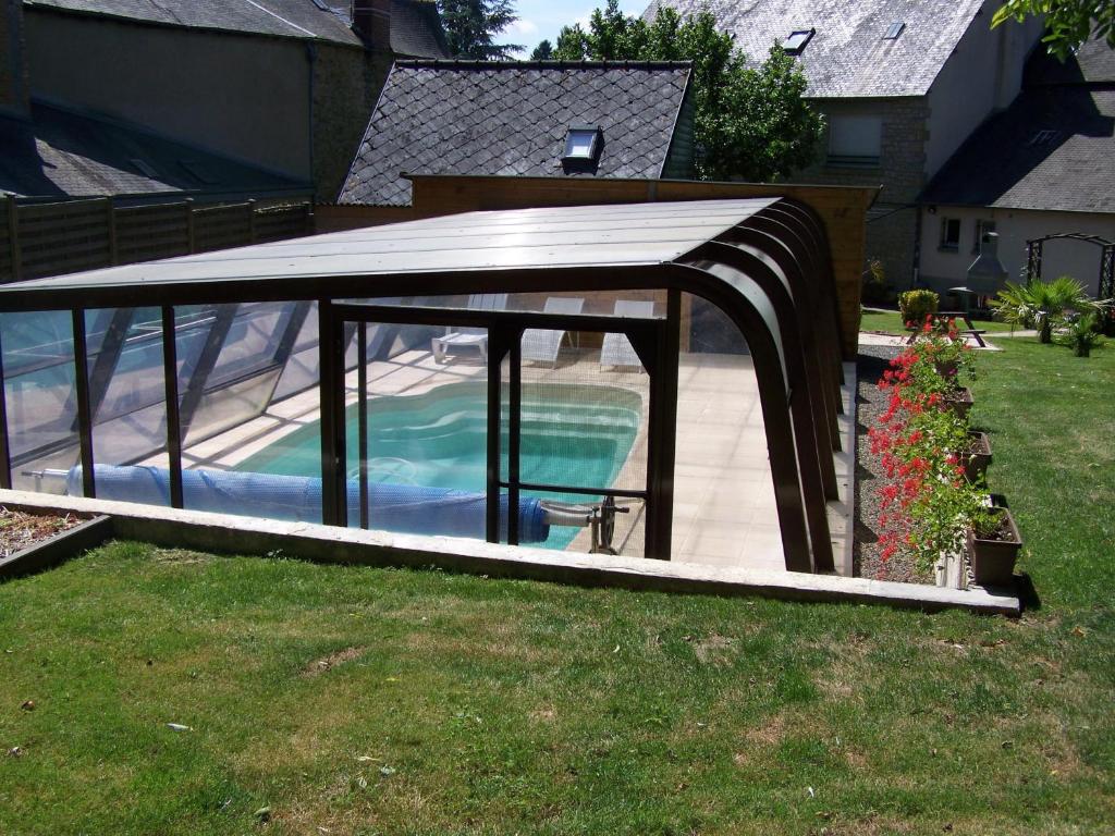 a pavilion with a swimming pool in a yard at Ker-Loën in Antrain