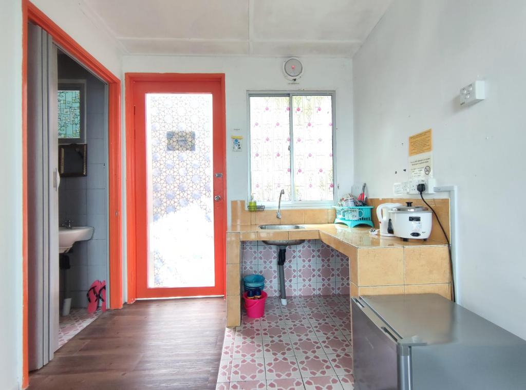 a kitchen with a sink and a red door at Nulu View Cabin in Kundasang