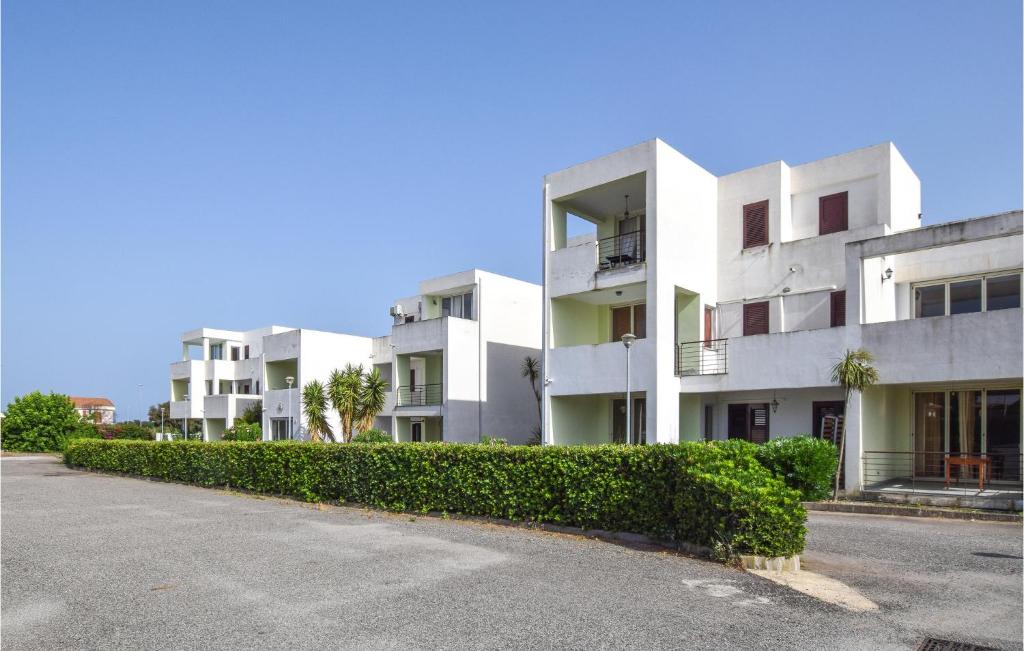 a row of white apartment buildings on a street at Cozy Apartment In Isca Marina With Wifi in Isca sullo Ionio