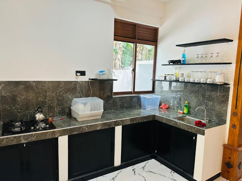 una cocina con encimeras de mármol blanco y negro en Beach heaven villa, en Matara