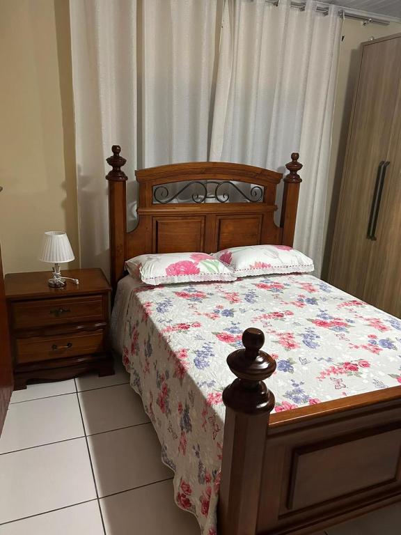 a bedroom with a bed and a table with a lamp at casa familiar da gilvana in São Gabriel