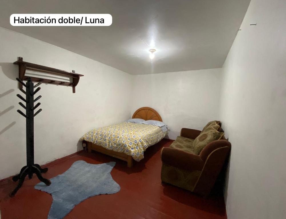 een slaapkamer met een bed en een stoel in een kamer bij Casa Katya Cusco in Cuzco