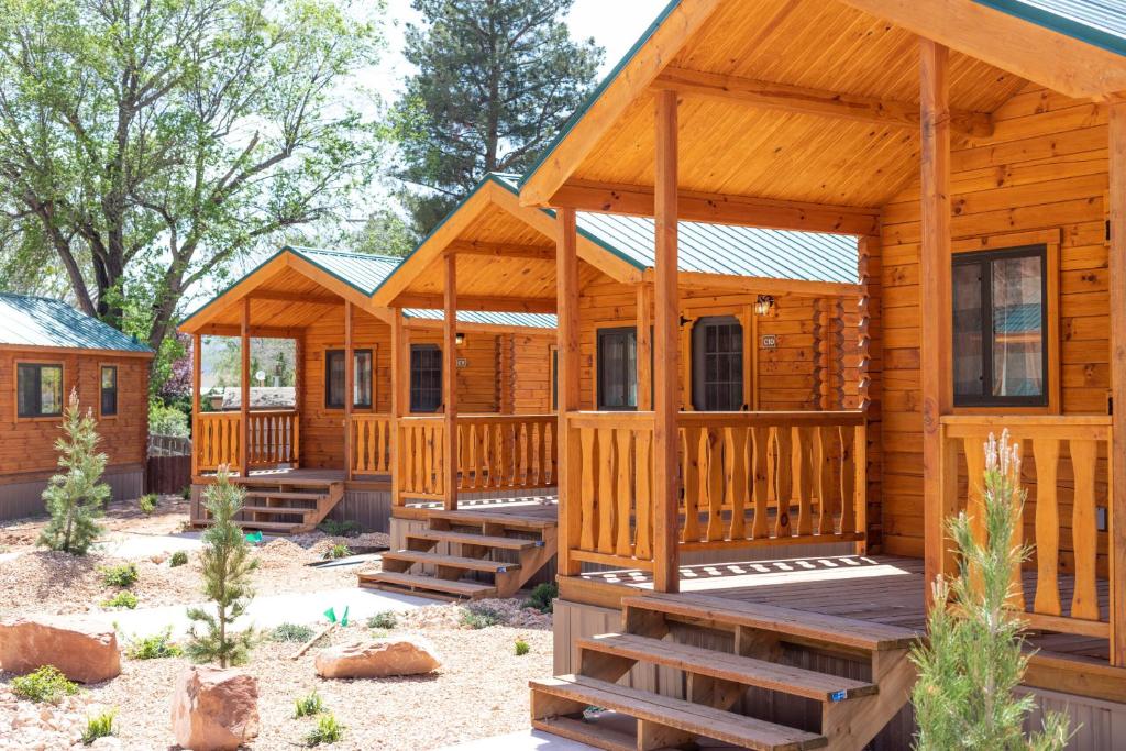 une cabane en rondins avec une véranda et une terrasse dans l'établissement Zion Canyon Cabins, à Springdale