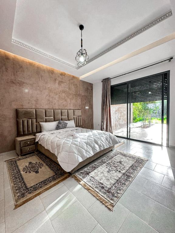- une chambre avec un grand lit et une grande fenêtre dans l'établissement Villa Marrakesh White Dreams, à Marrakech