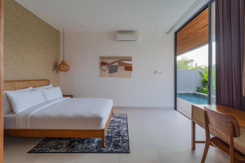 1 dormitorio con cama, mesa y piscina en Villa Sagrada in Canggu Bali, en Dalung