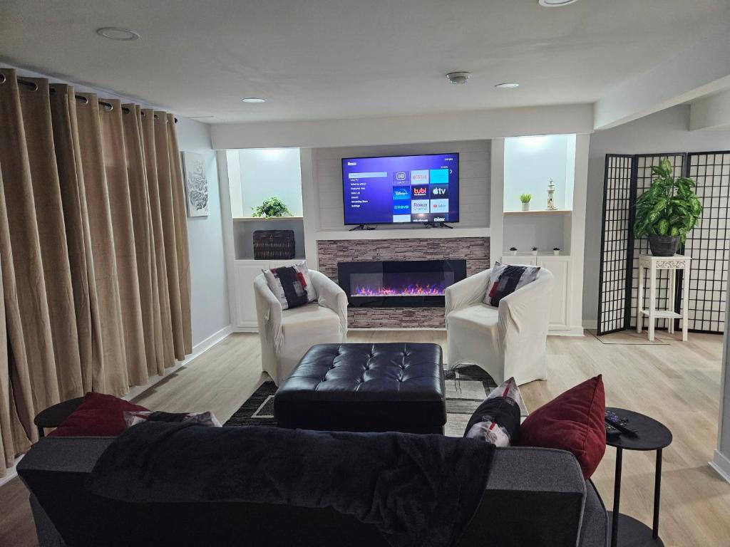uma sala de estar com um sofá e uma televisão em Newly Renovated Suite em Regina