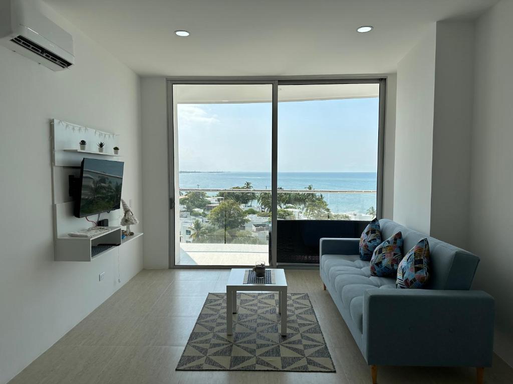 uma sala de estar com um sofá e vista para o oceano em EXCLUSIVO APTO CON VISTA Y FRENTE AL MAR em Gaira