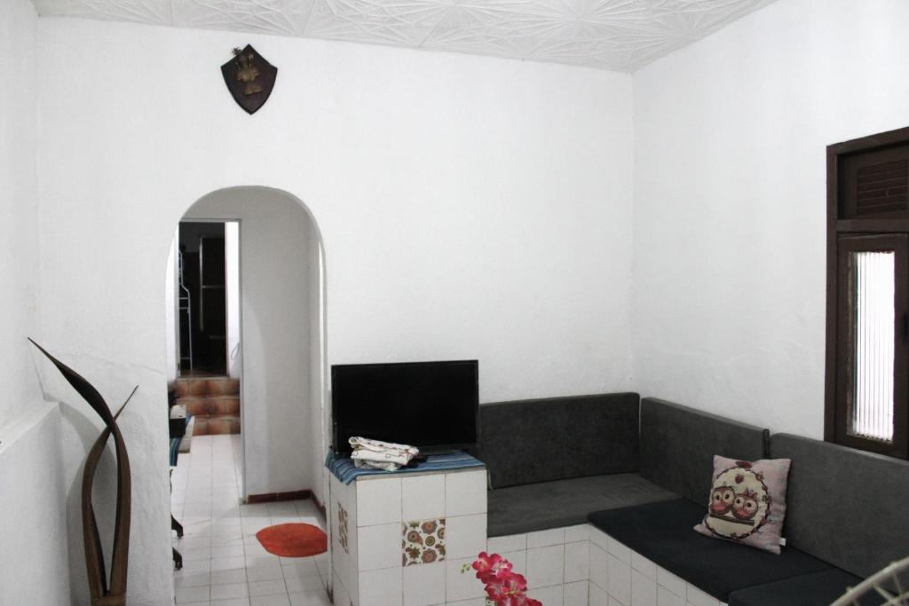 a living room with a couch and a tv at Casa de Alvenaria- Mauá in Mauá