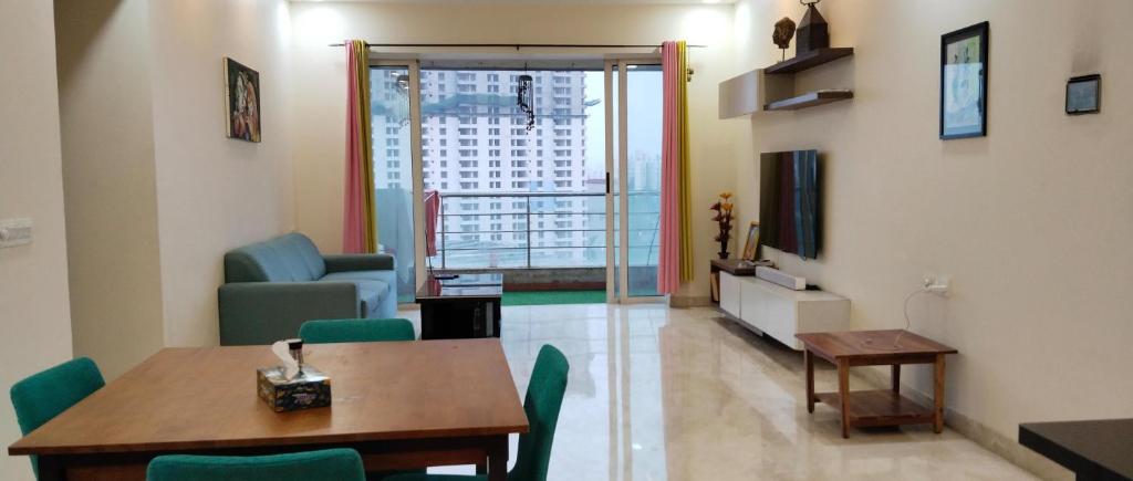 a living room with a table and chairs and a window at GM Hospitality Services pune in Pune