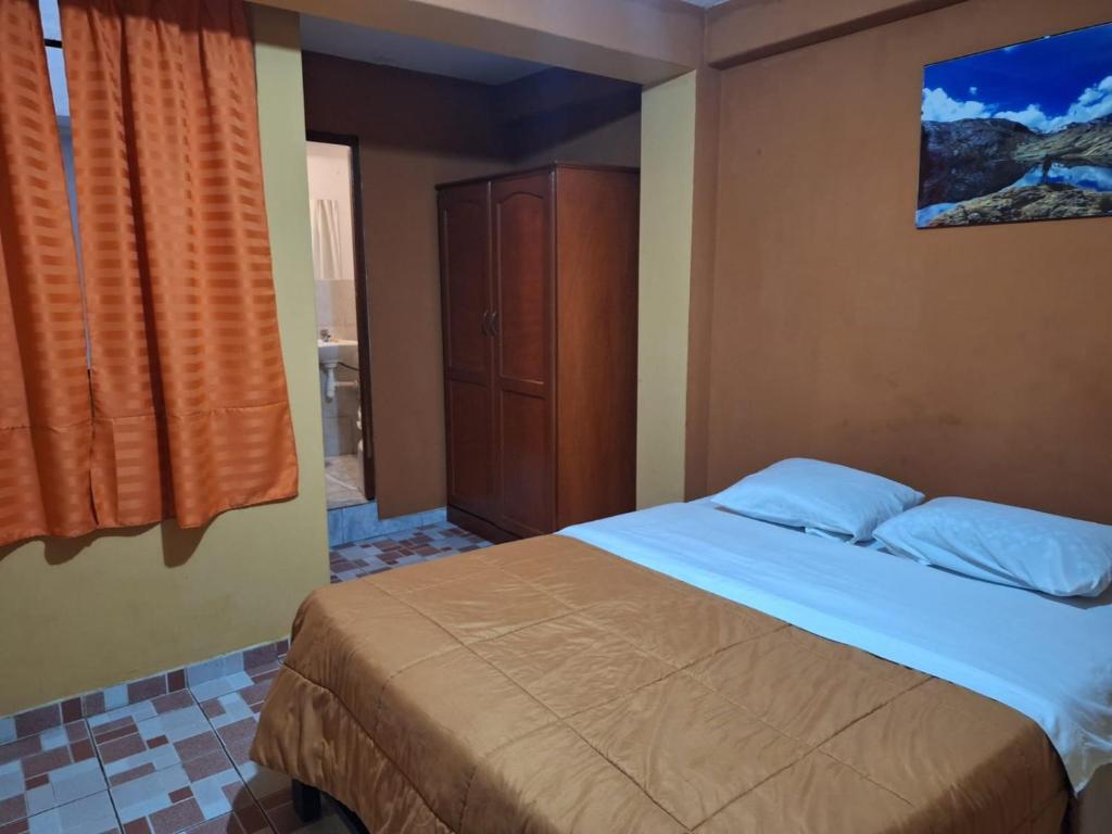 1 dormitorio con 1 cama y armario de madera en Montañero Hostel II, en Huaraz