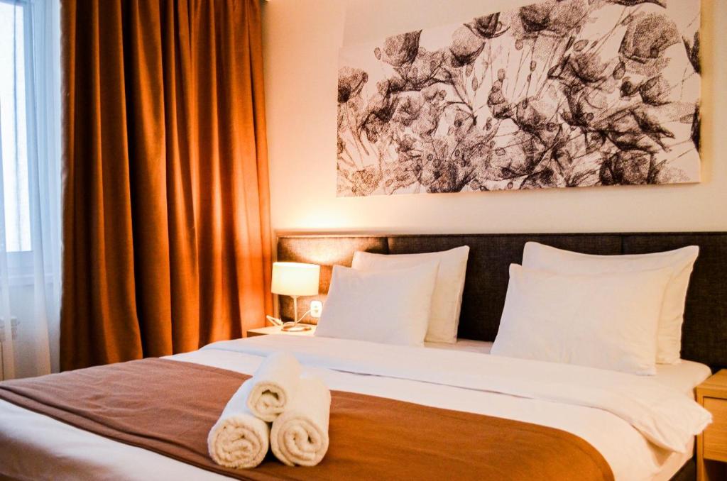 1 dormitorio con 1 cama con toallas en Yes Апарт-отель, en Astana