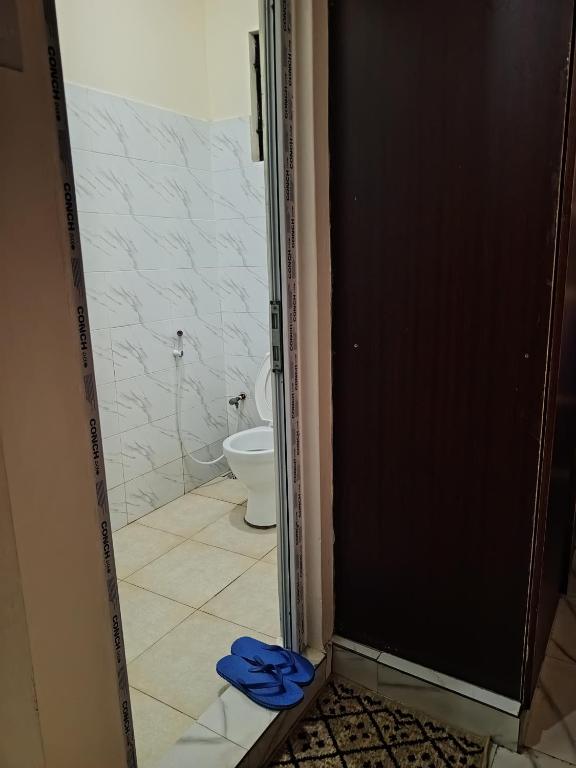 une porte ouverte menant à une salle de bains pourvue de toilettes. dans l'établissement Jackie homes, à Mombasa