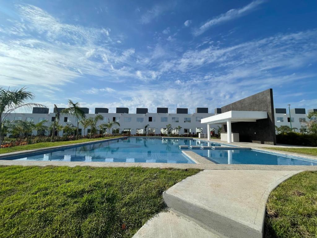 a swimming pool in front of a building at Bonita casa muy cómoda y con piscina in Naranjo