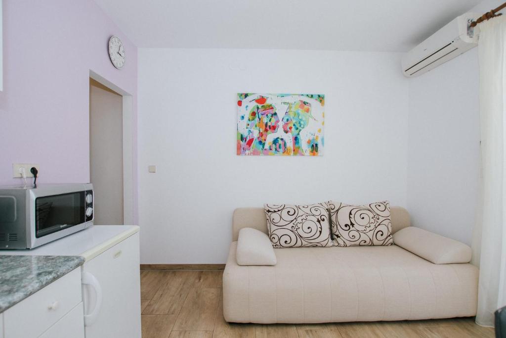 una sala de estar con sofá y una pintura en la pared en Apartments Civadelić, en Trogir