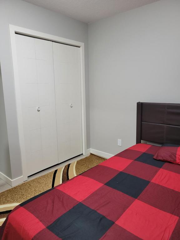 a bedroom with a bed and white cabinets at Brand New 2 Bedroom Basement Suite with Wifi in Edmonton