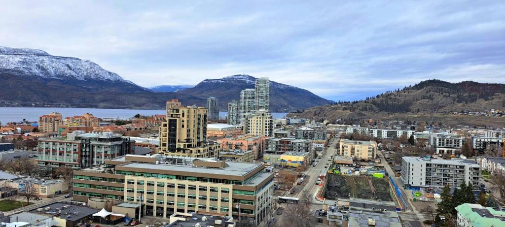 an aerial view of a city with buildings and mountains at Alice in Kelowna in Kelowna