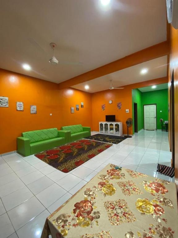 a living room with a green couch and a fireplace at Pelangi Homestay 2 in Bachok