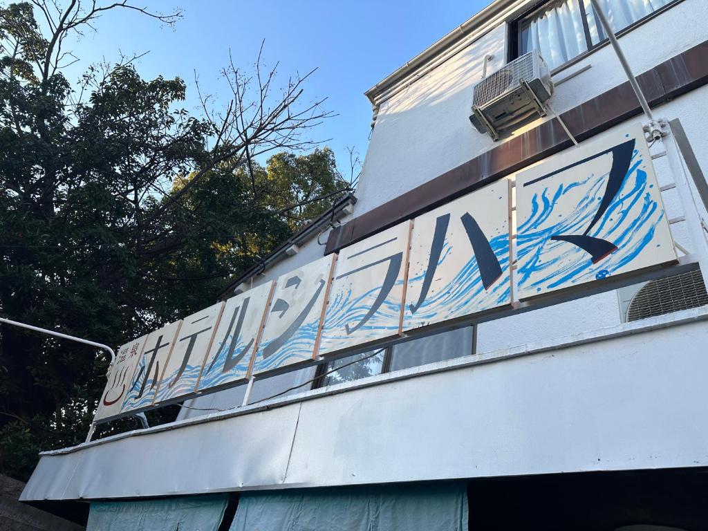 een bord aan de zijkant van een gebouw bij Hotel shirahama in Shirahama